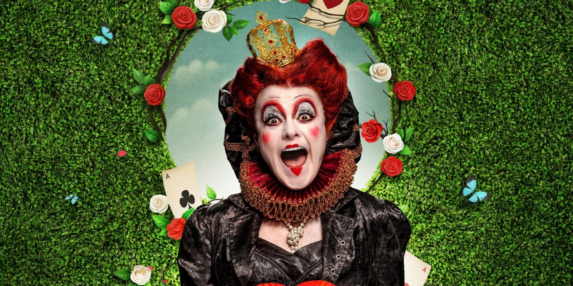 A female dressed as the Queen of Hearts. She is surrounded by a green shrub, butterflies and playing cards.